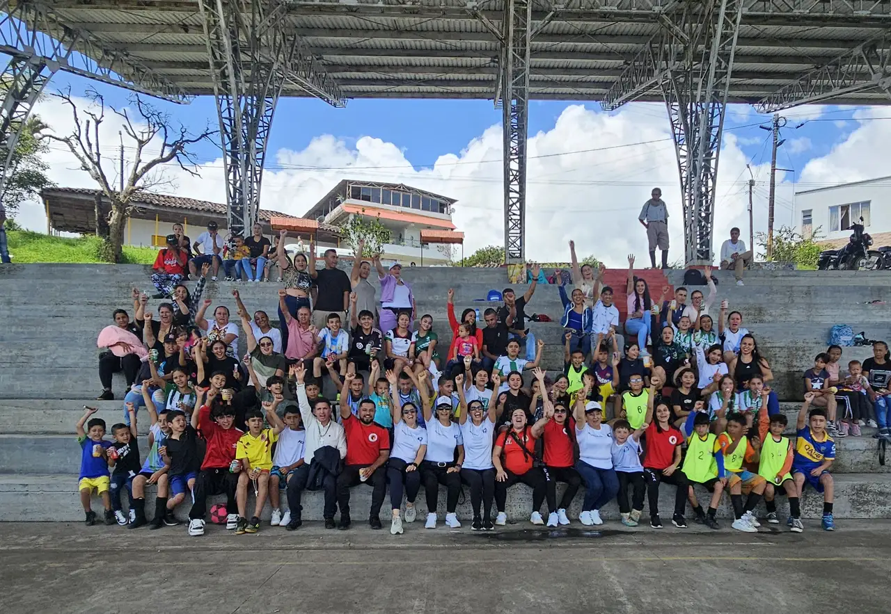 Alpha FC participants and community members gathered together on a covered court in Pereira