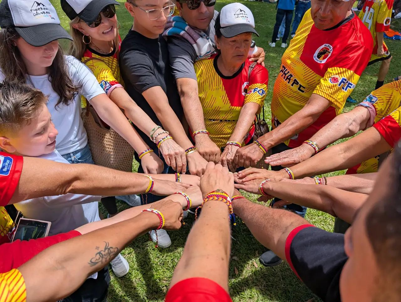 Alpha FC players and coaches bringing their hands together before an activity in Pereira