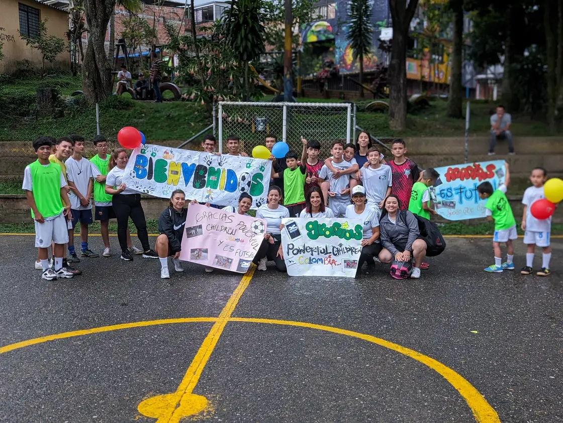Alpha FC participants gathered with community banners on a court in Pereira