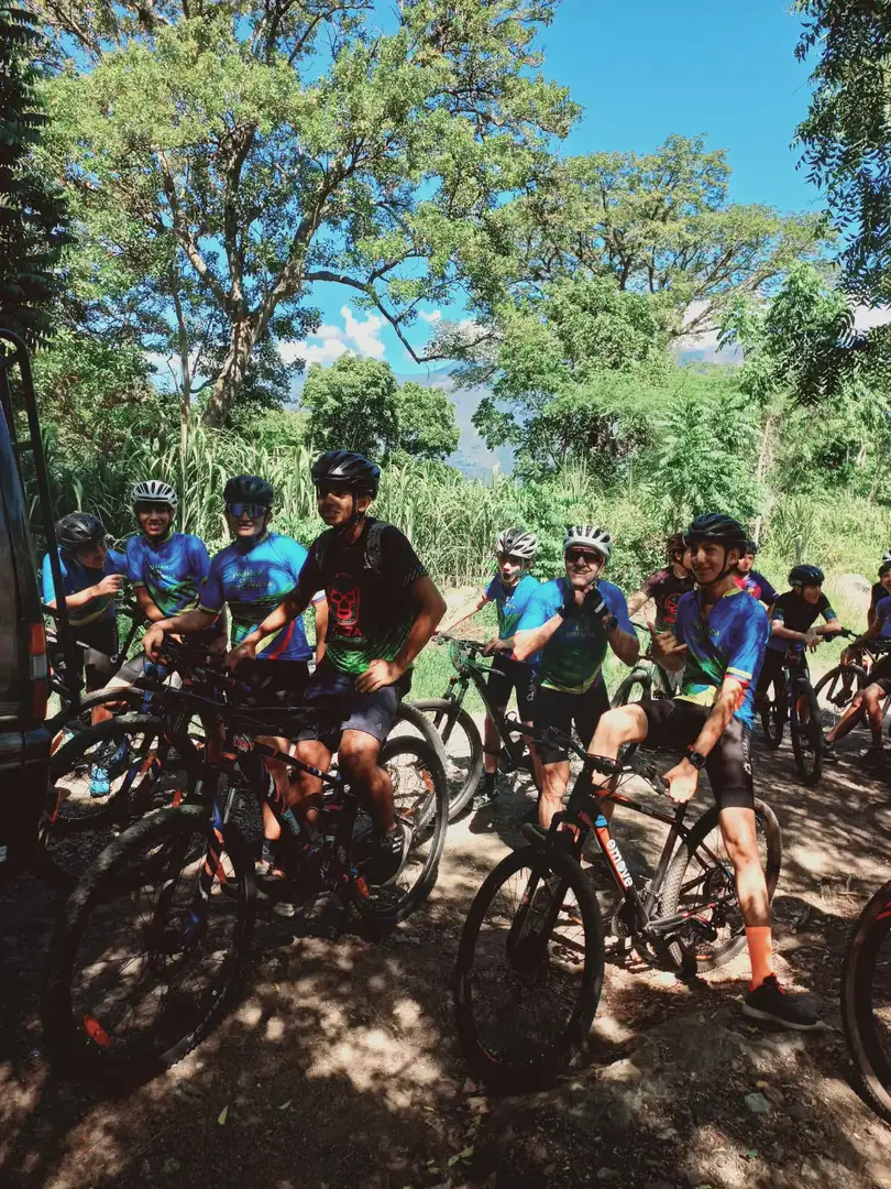 Young Pedalea con Conciencia riders traveling together on a wooded trail near Cabrera