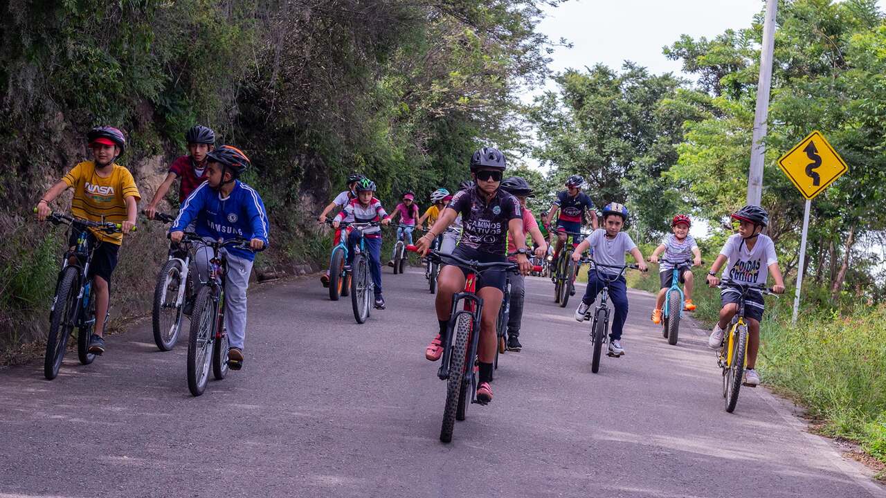 Pedalea con Conciencia riders cycling together on a rural road near Cabrera
