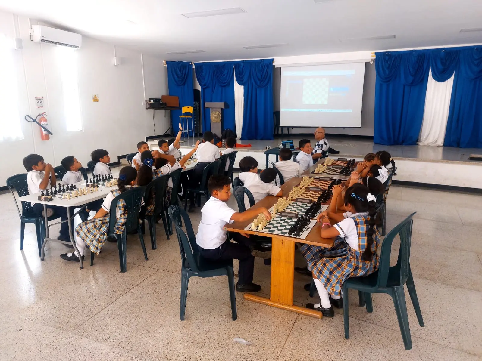 Students gathered around chessboards during a school session in Santa Marta